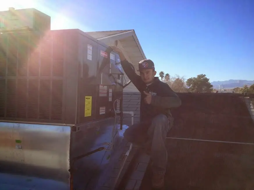 HVAC technician performing AC Tune-Up on a rooftop unit in South Park